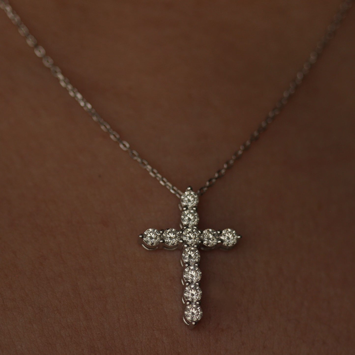 Silver moissanite cross necklace on model's neck