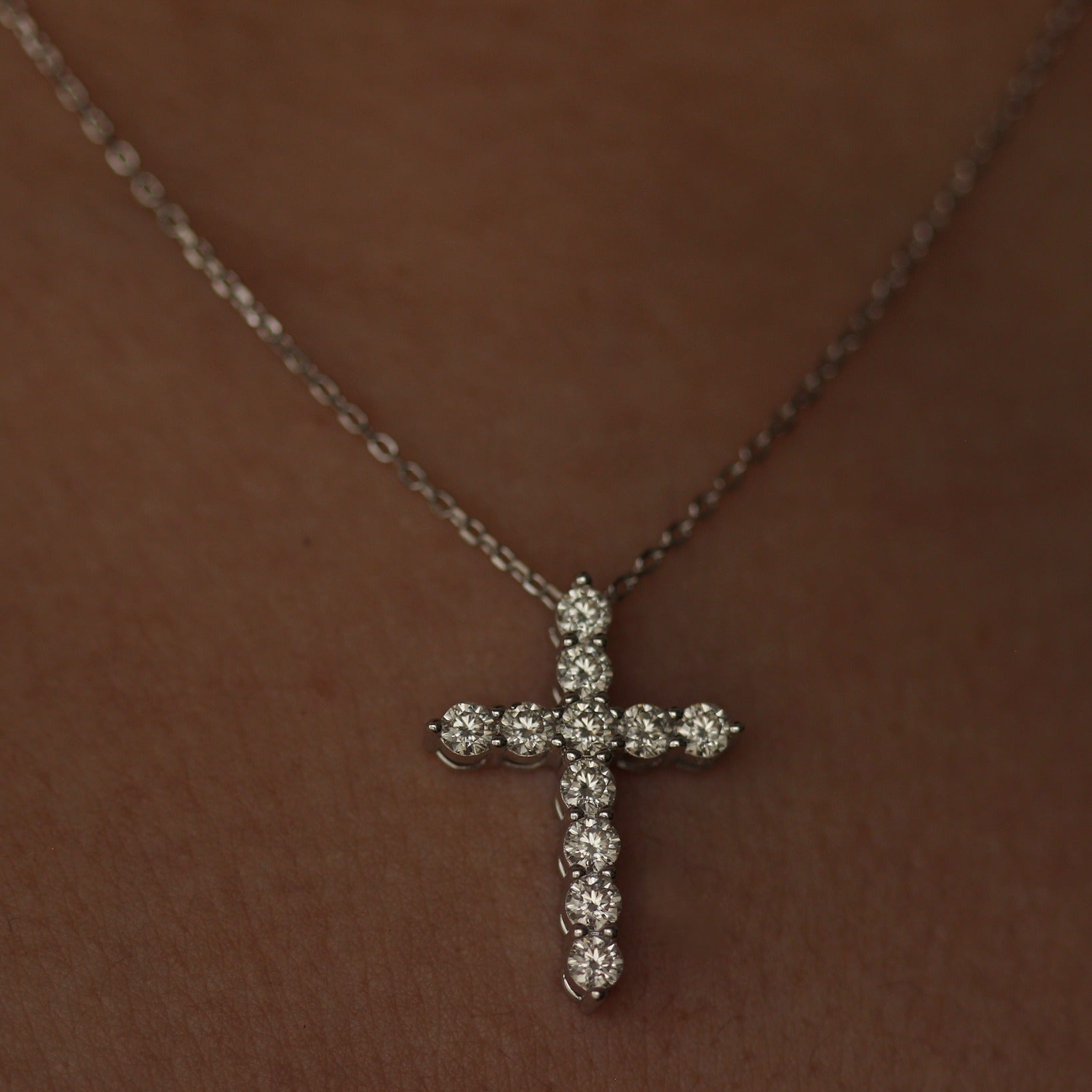 Silver moissanite cross necklace on model's neck