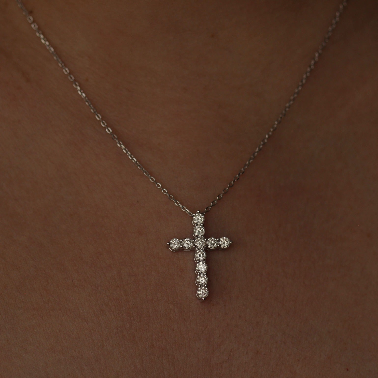 Silver moissanite cross necklace on model's neck