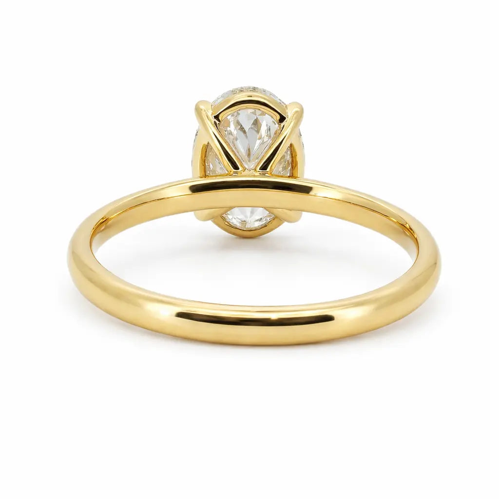 Gold oval lab grown diamond engagement ring on white background