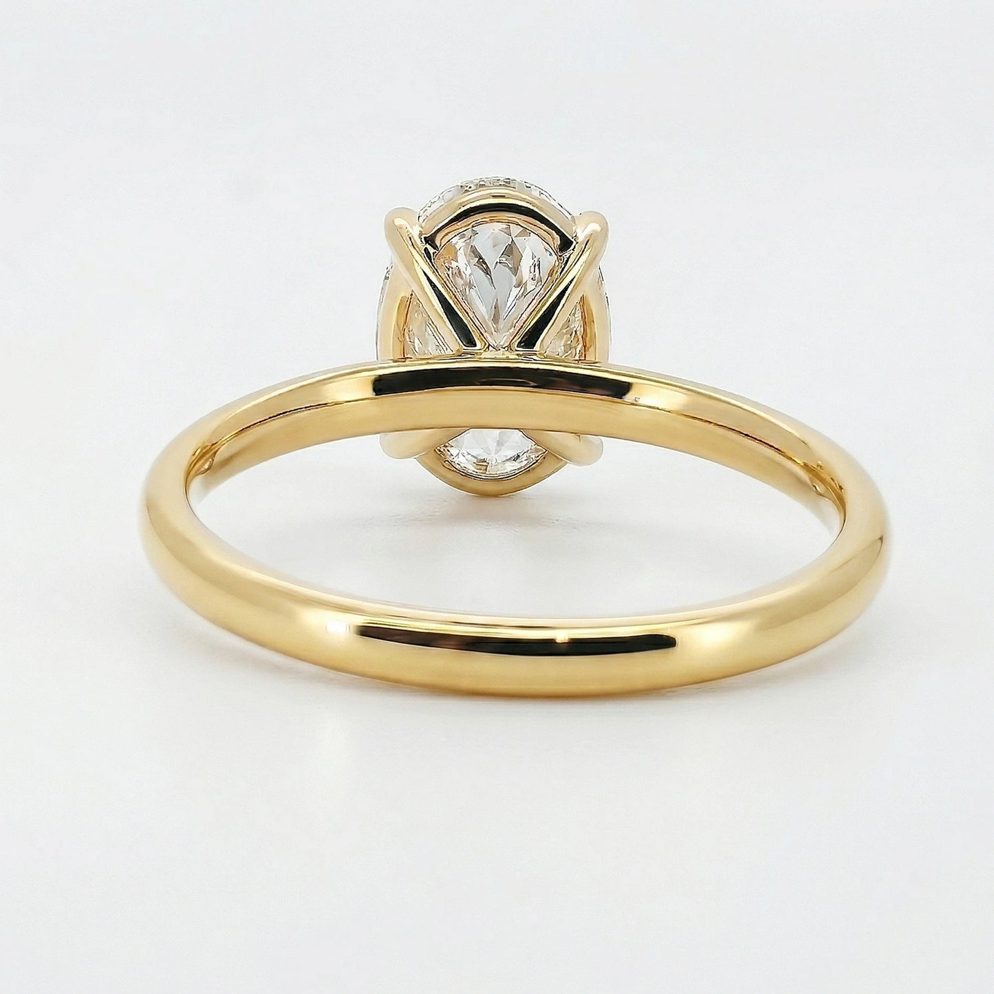 Gold oval lab grown diamond engagement ring on white background