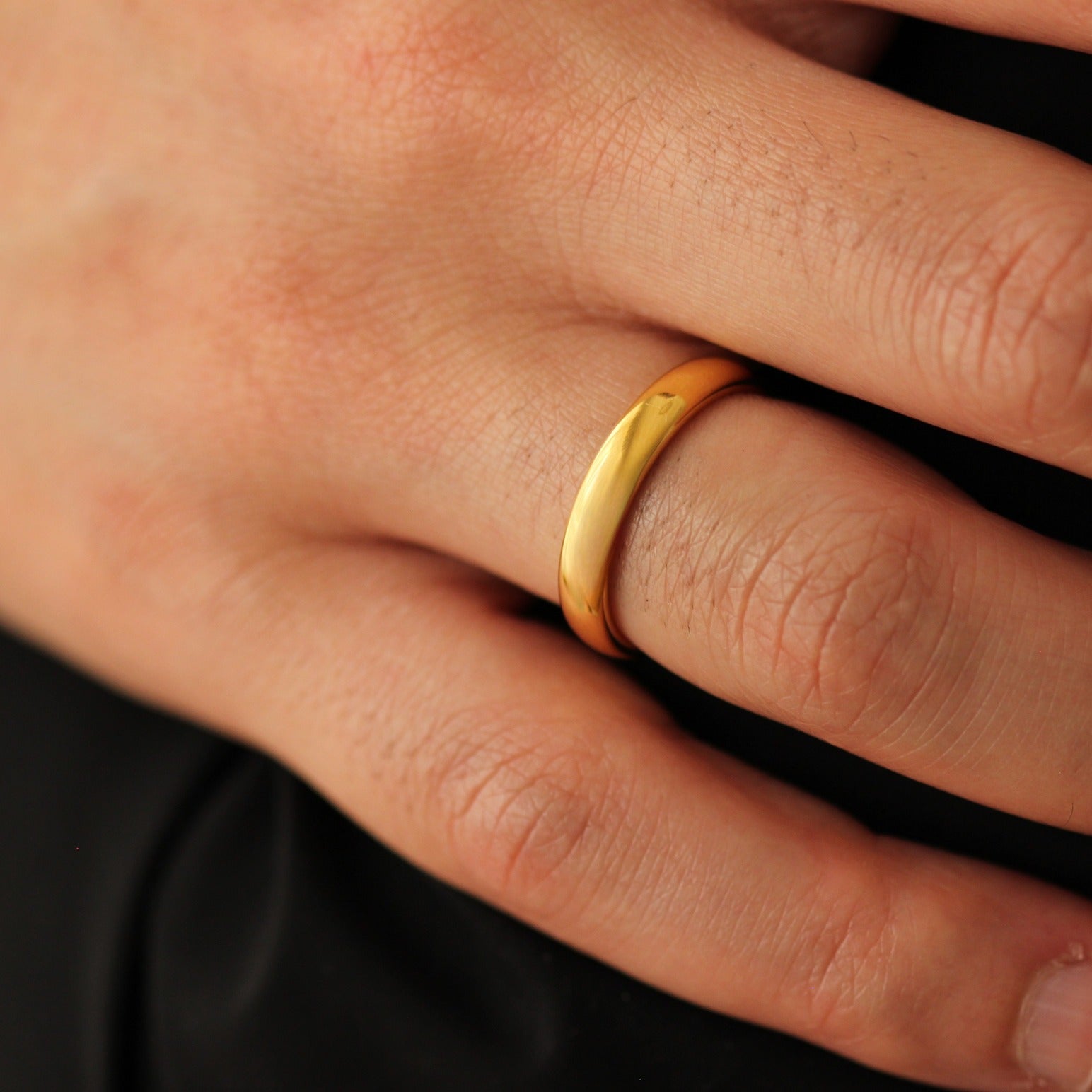 polished gold wedding band 4mm width on men's hand