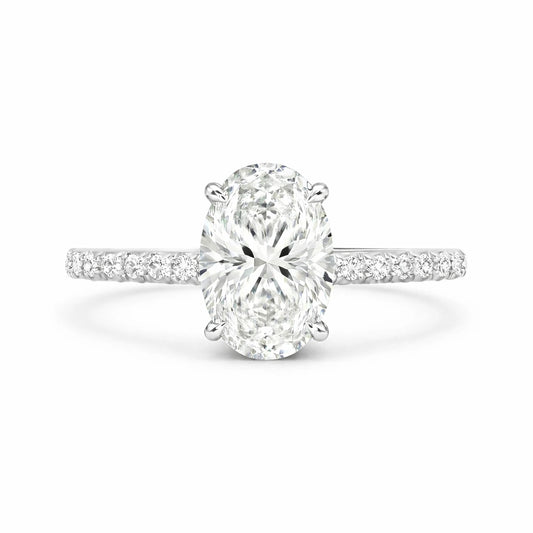 2 carat oval moissanite ring with pave band on white background
