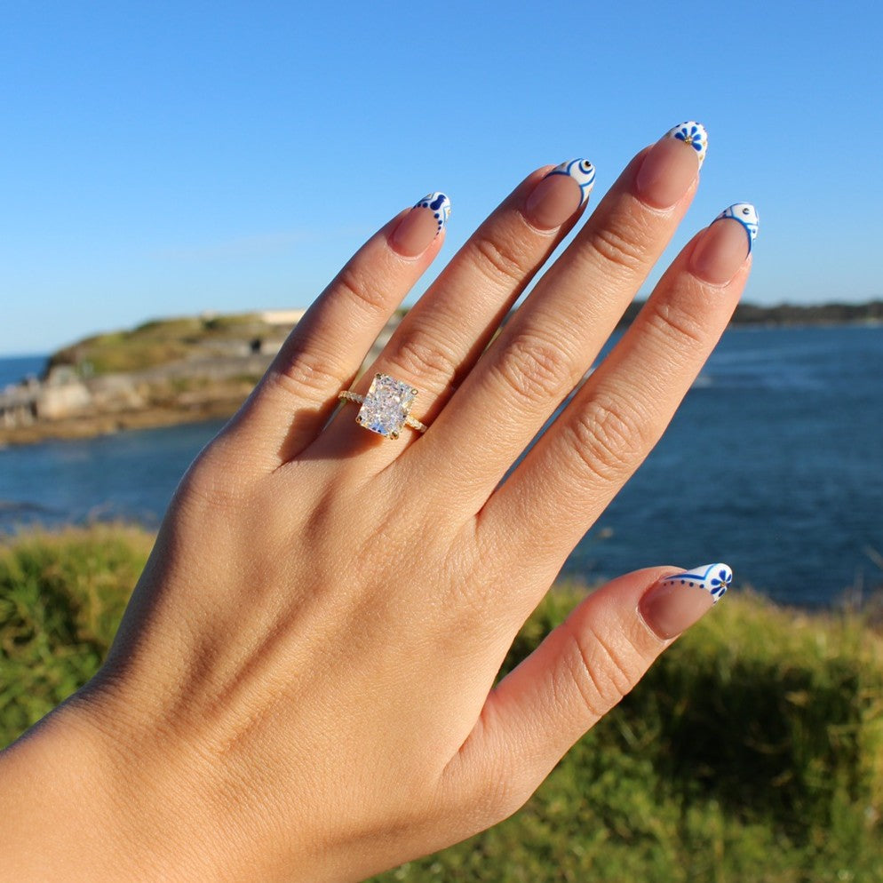 Gold radiant rectangle ring on hand at La Perouse Beach, Sydney