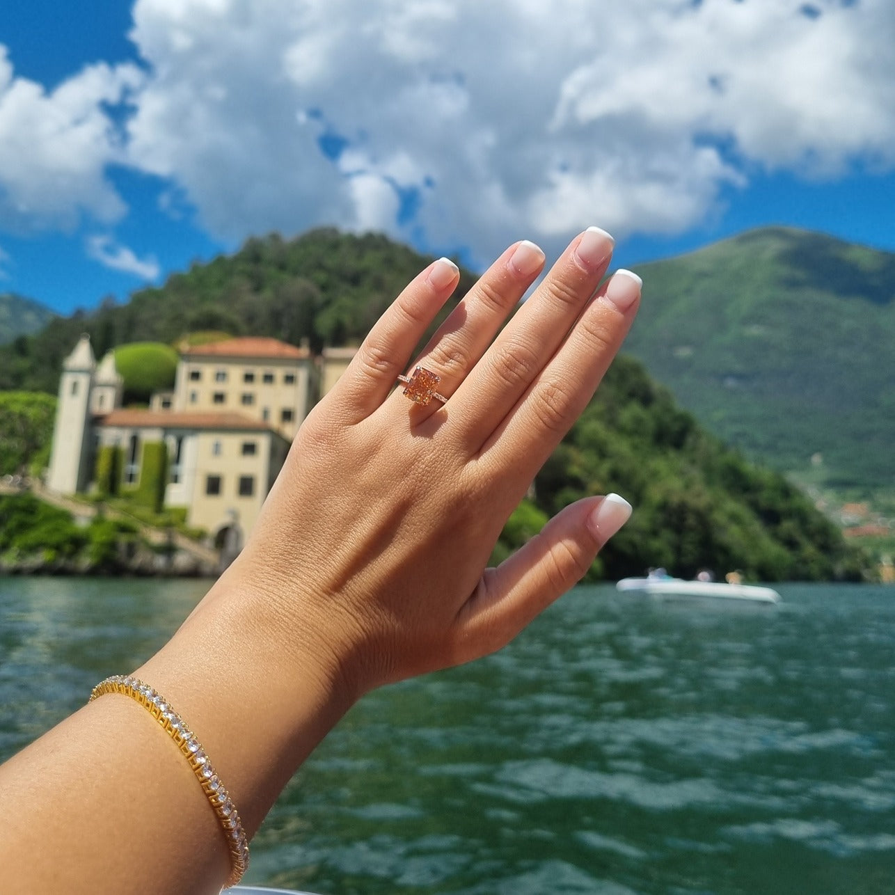 Rose gold radiant ring in front of Villa Del Balbianello Lake Como