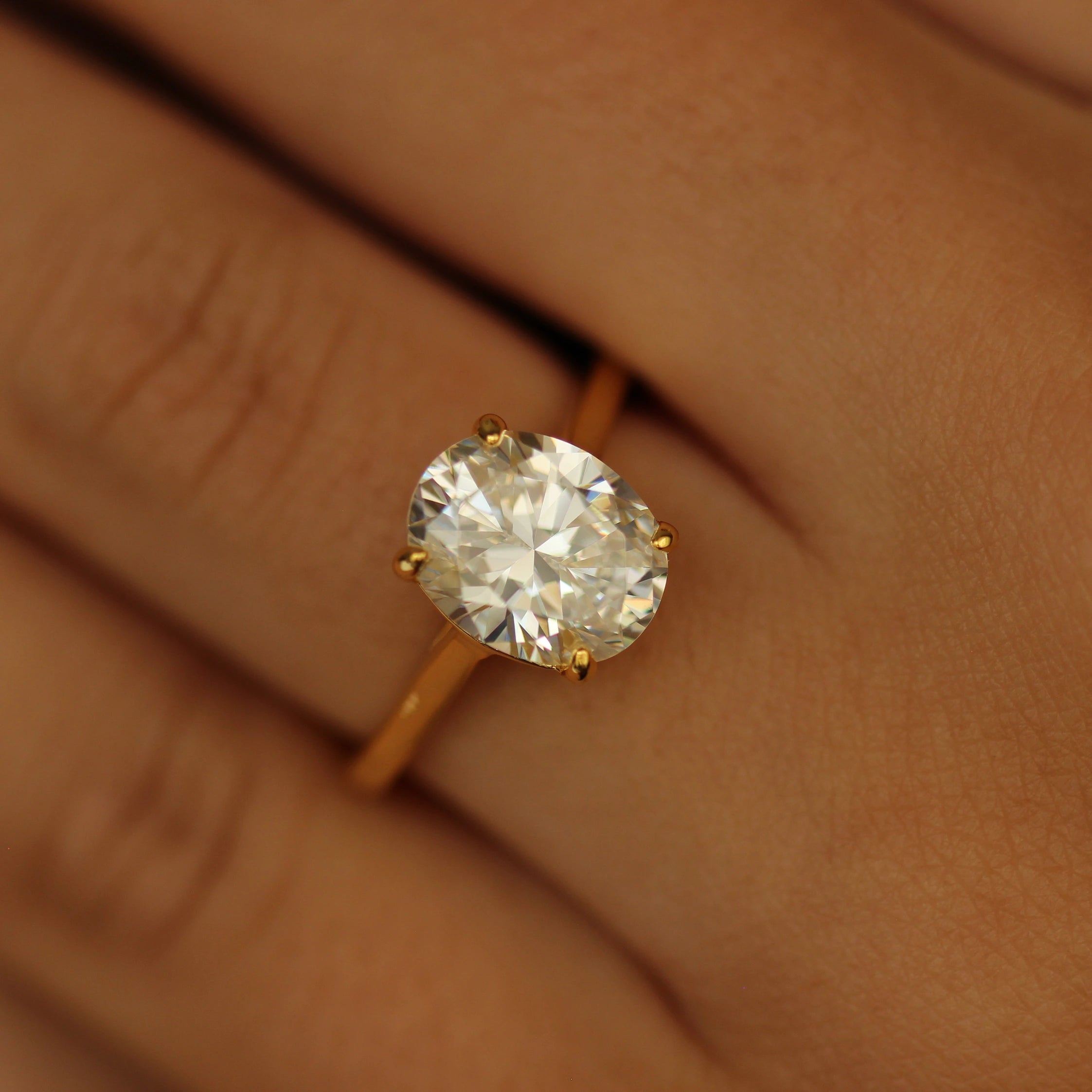 3 carat oval ring with gold band on hand