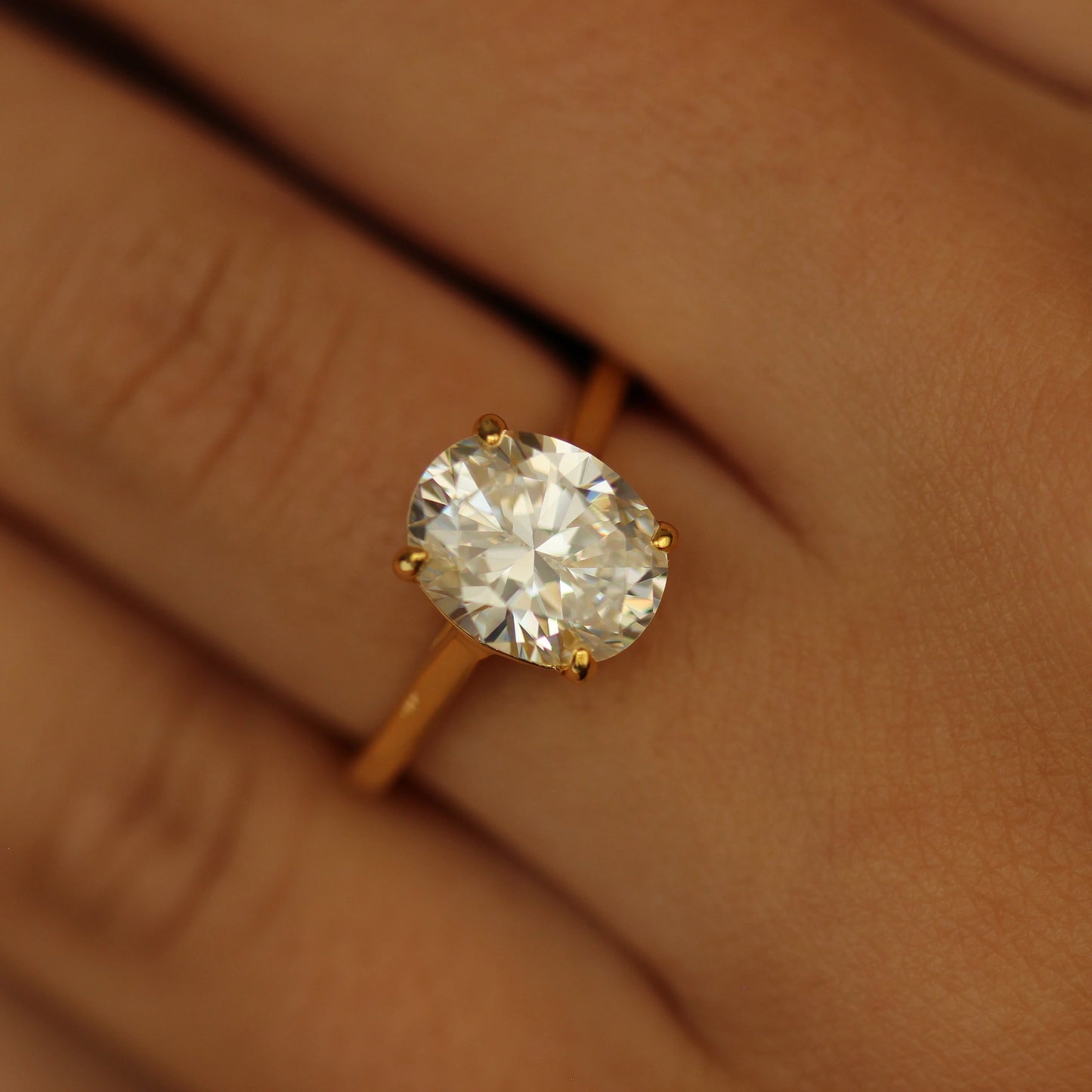 3 carat oval ring with gold band on hand