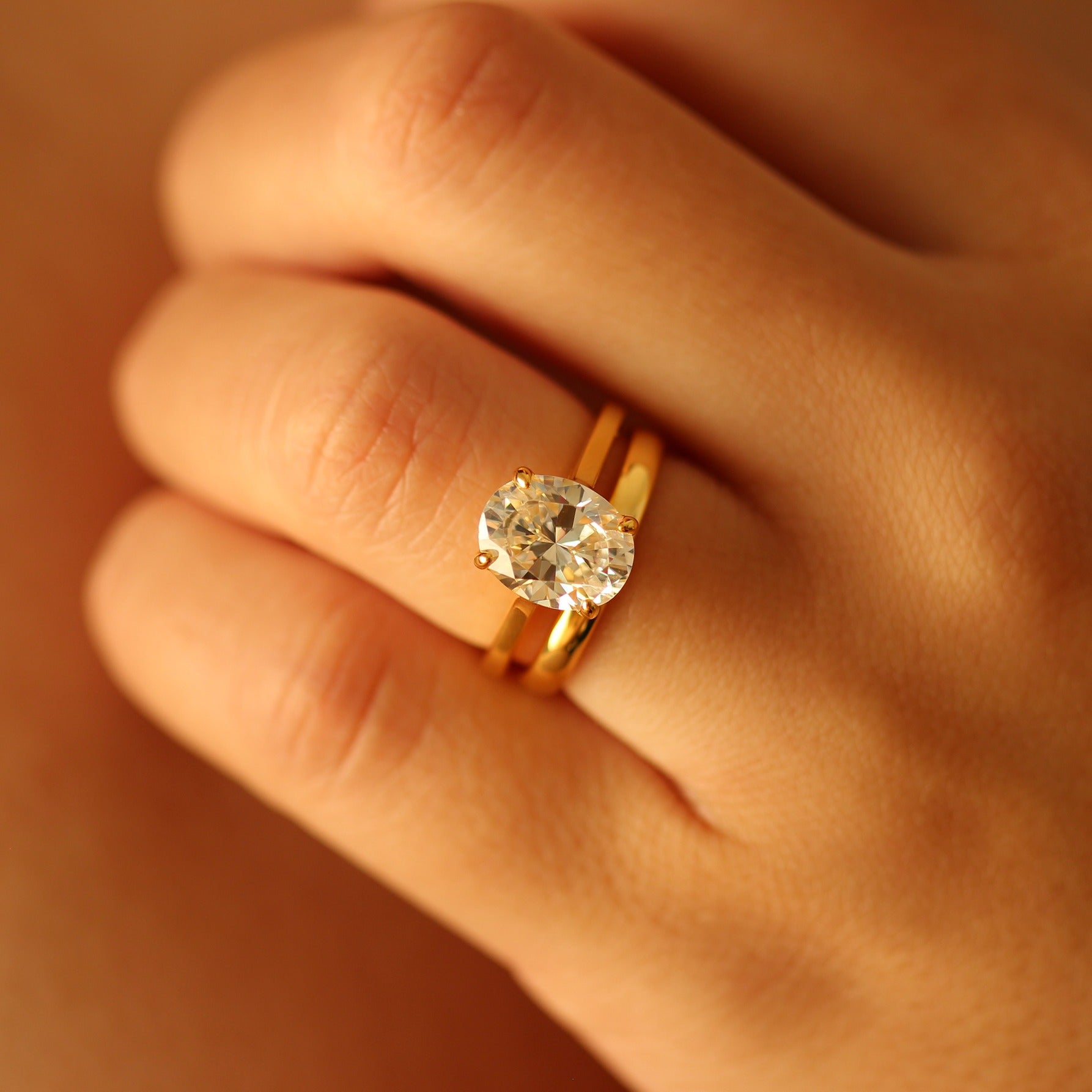 Oval gold vermeil ring on hand with gold vermeil wedding band