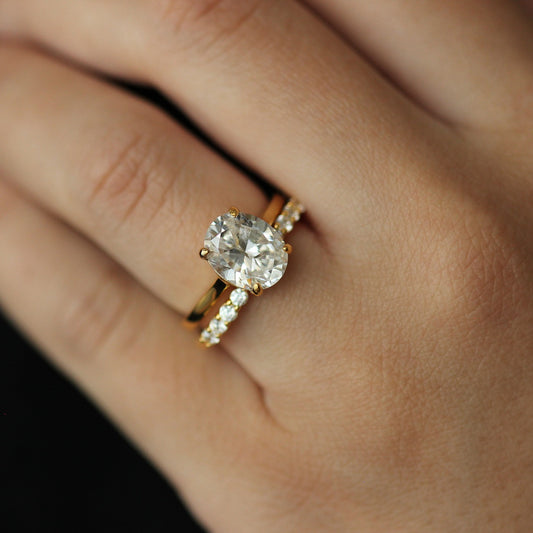 gold oval ring and gold open band on hand