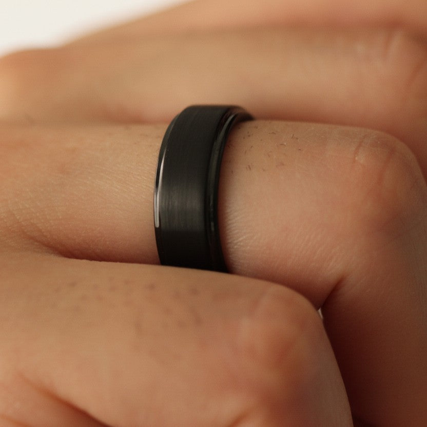 Close up of hand wearing Black Men’s Ring 8mm with stepped edge