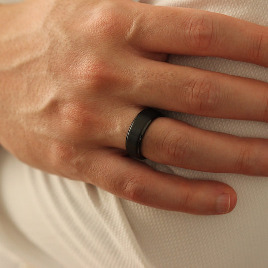 Male model with hands crossed wearing Black Men’s Ring 8mm with stepped edge