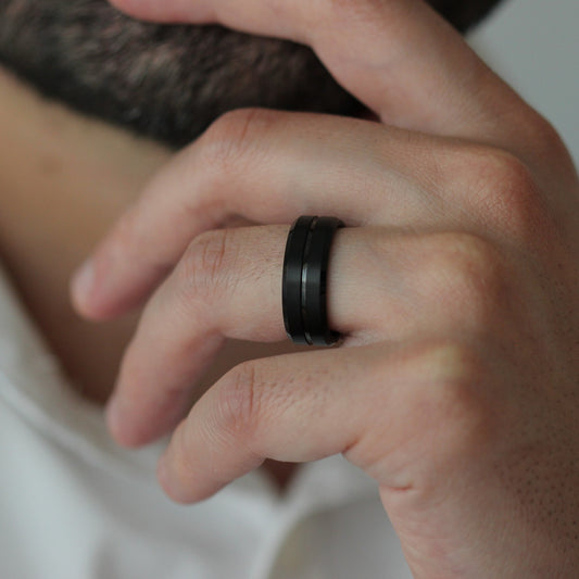 Male model wearing black men’s tungsten ring with centre groove