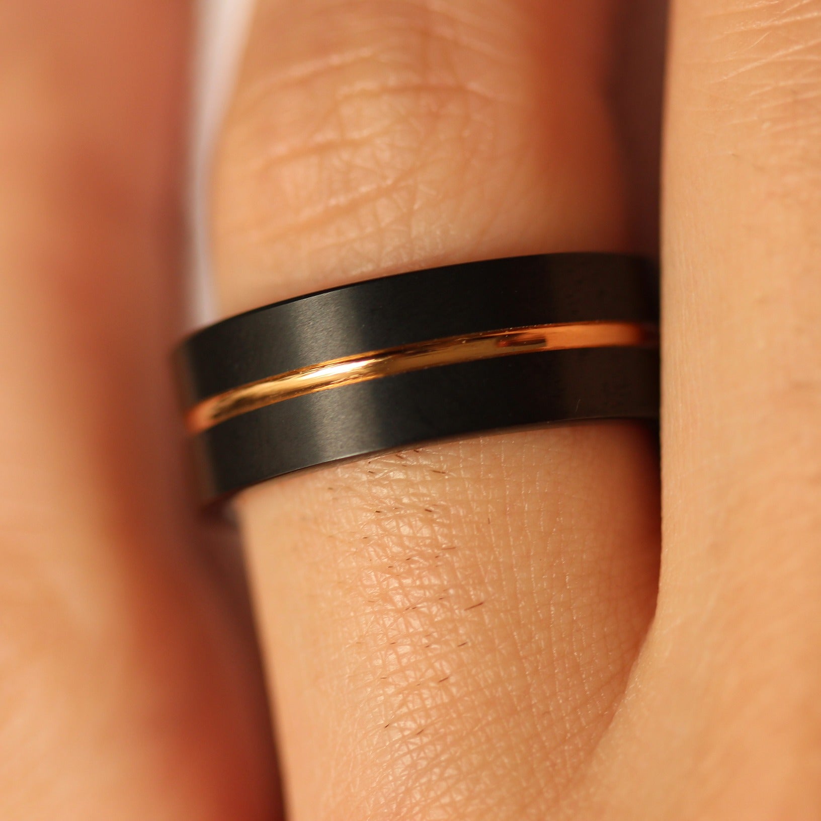 8mm black tungsten men's ring with rose gold centre groove on hand