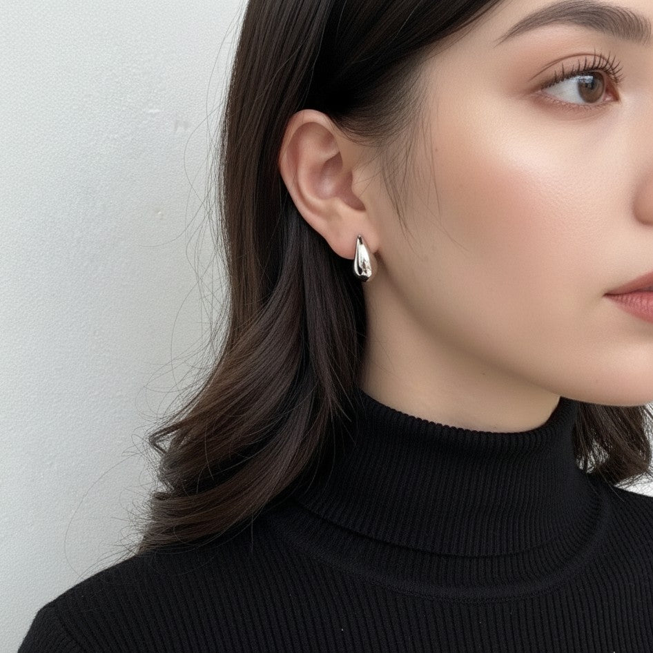 silver blob earrings on a model 