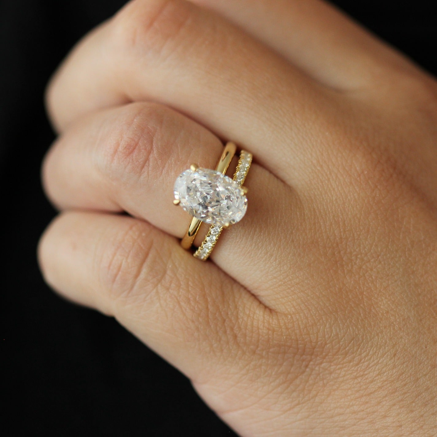 14k gold oval ring and 14k half eternity pave band on hand