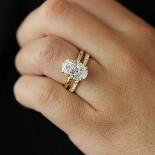 14k gold oval ring and 14k half eternity pave band on hand