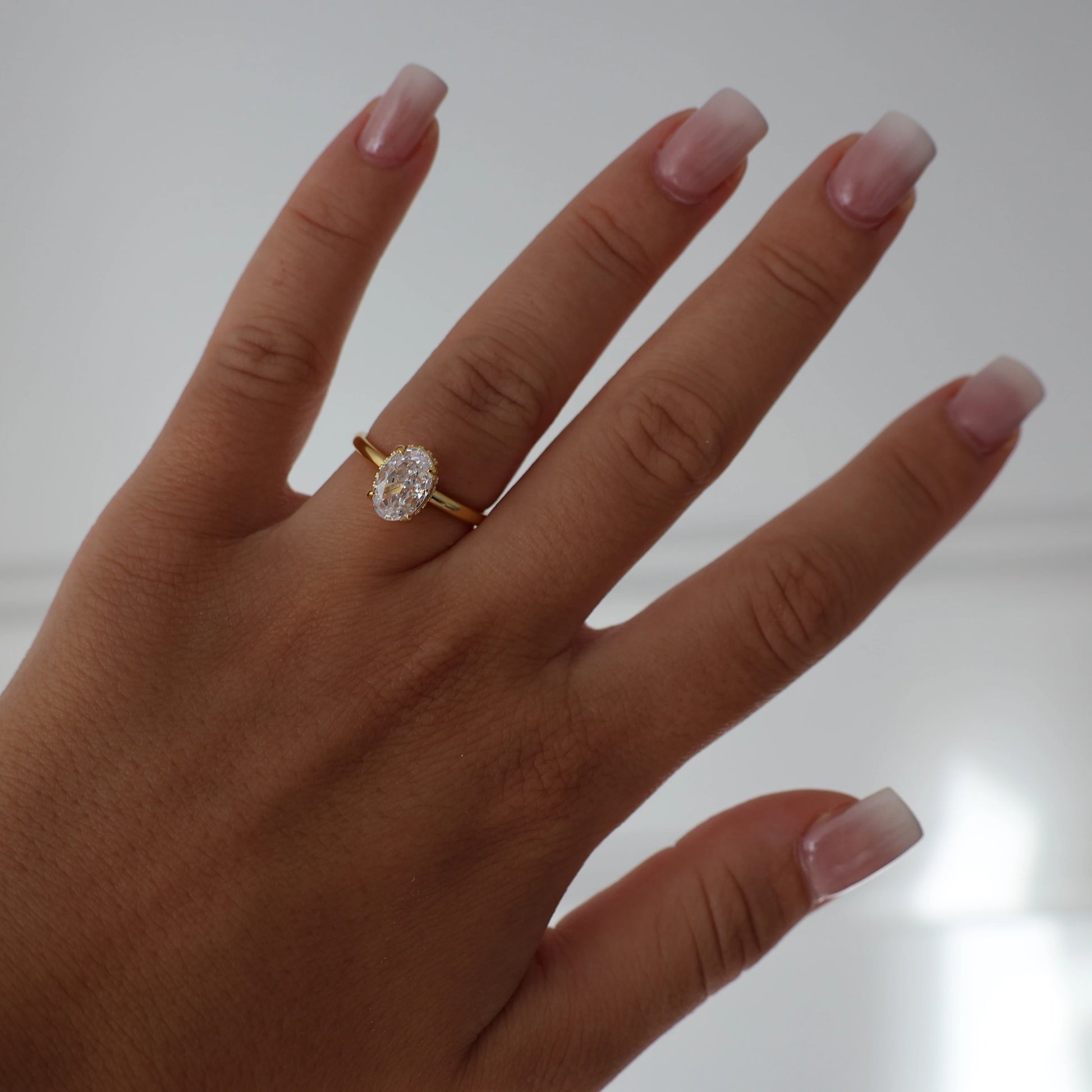 Gold 1.5 carat oval engagement ring with hidden halo