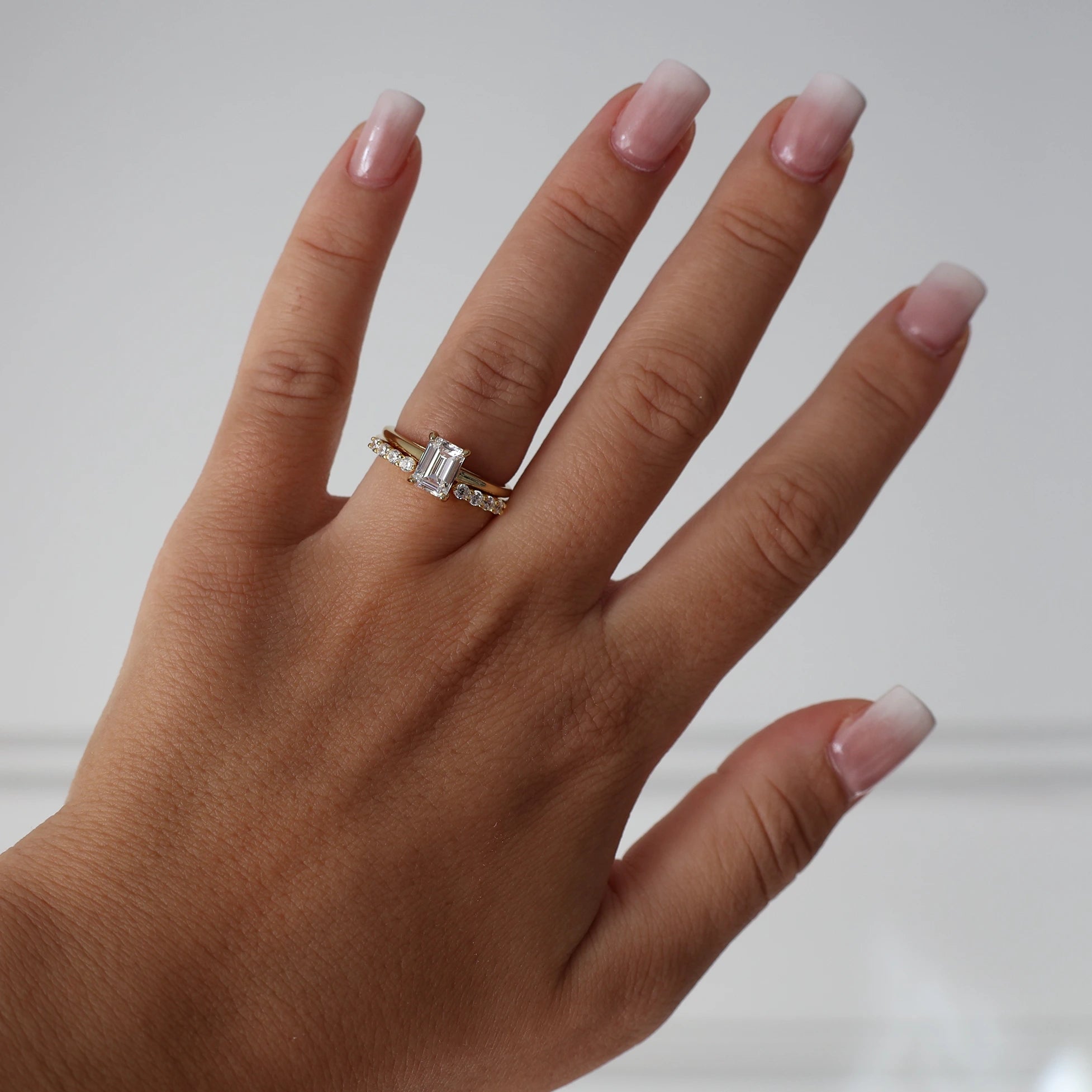 Gold 1 ct emerald cut cubic zirconia solitaire ring stacked with eternity ring
