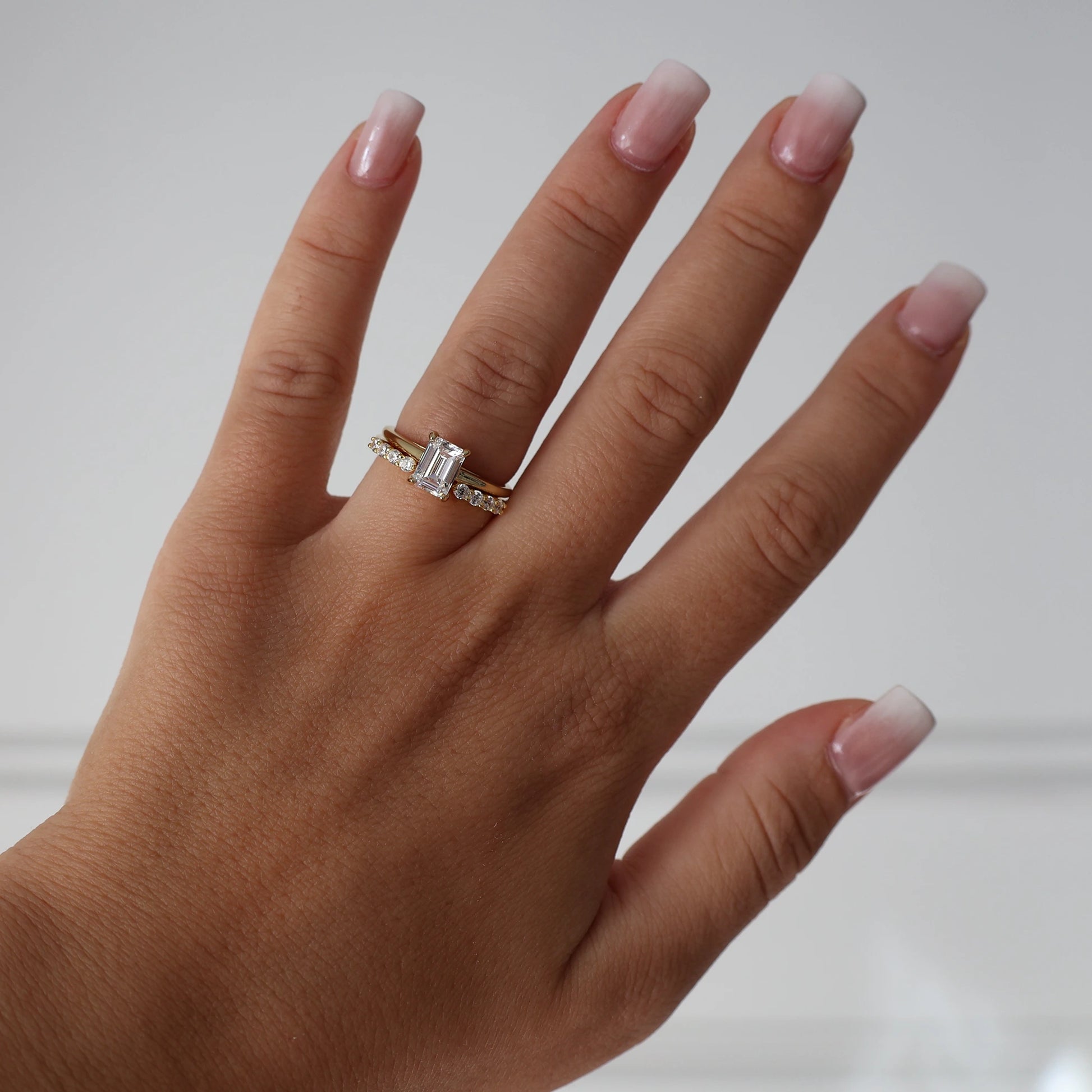 Gold 1 ct emerald cut cubic zirconia solitaire ring stacked with eternity ring