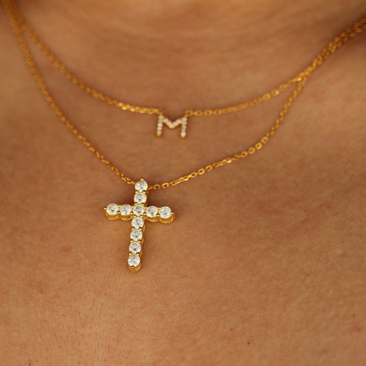 gold letter necklace stacked with gold cross necklace