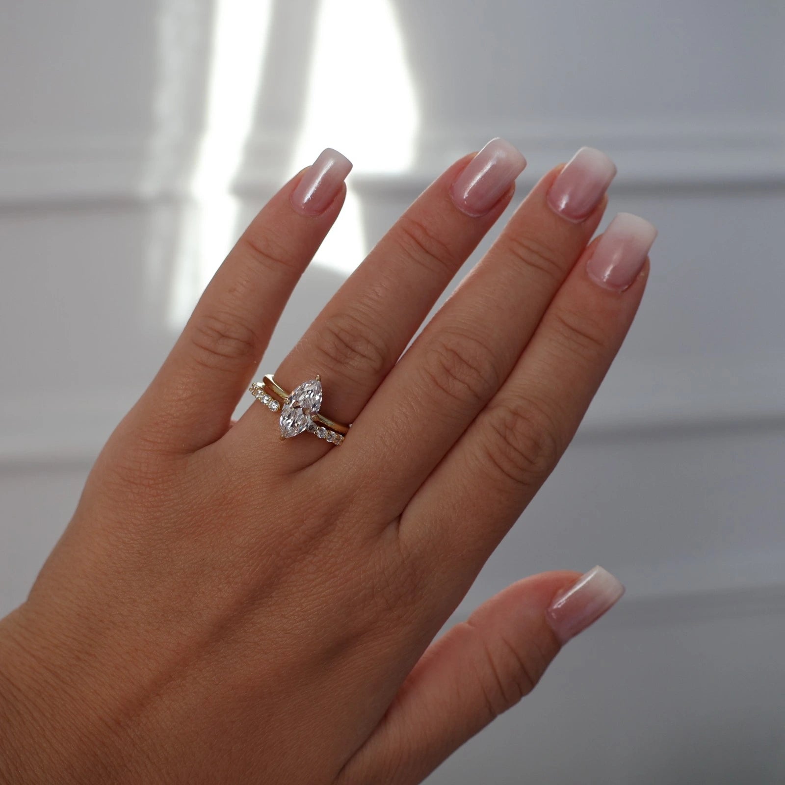 Gold marquise solitaire cubic zirconia engagement ring worn on hand
