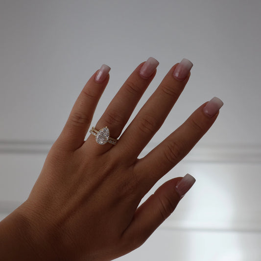 Gold pear shaped 3 ct cubic zirconia ring featuring pavé setting