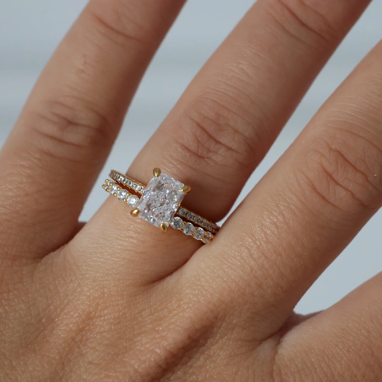 Gold 2 ct radiant cut CZ ring featuring pavé band
