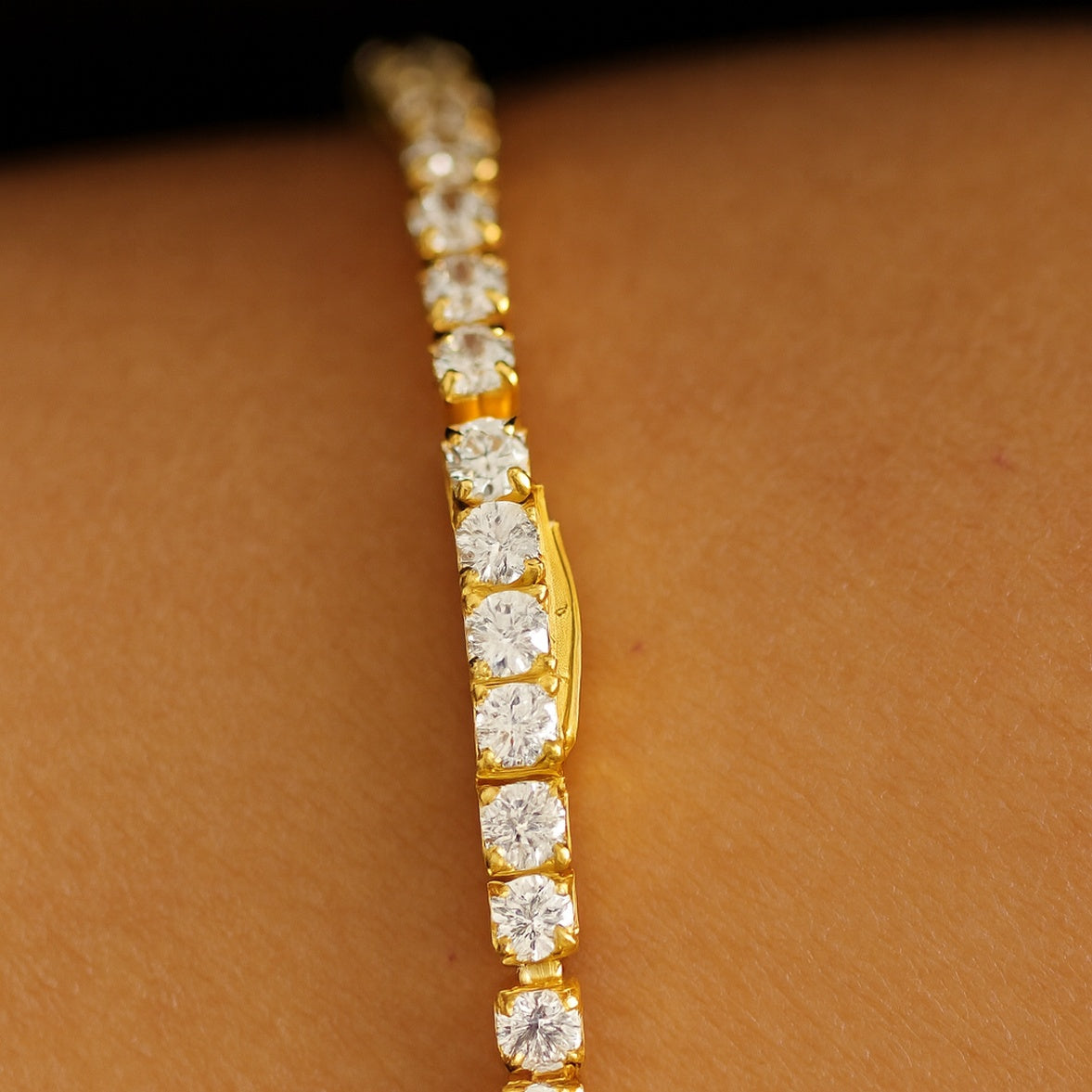 Close up of clasp on gold tennis bracelet