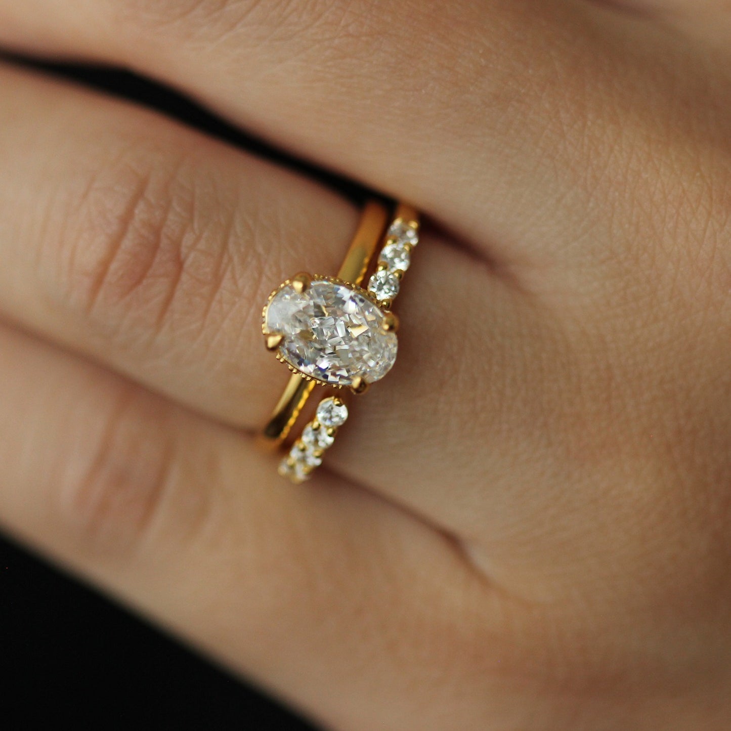 18k gold open wedding band with gold oval ring on hand