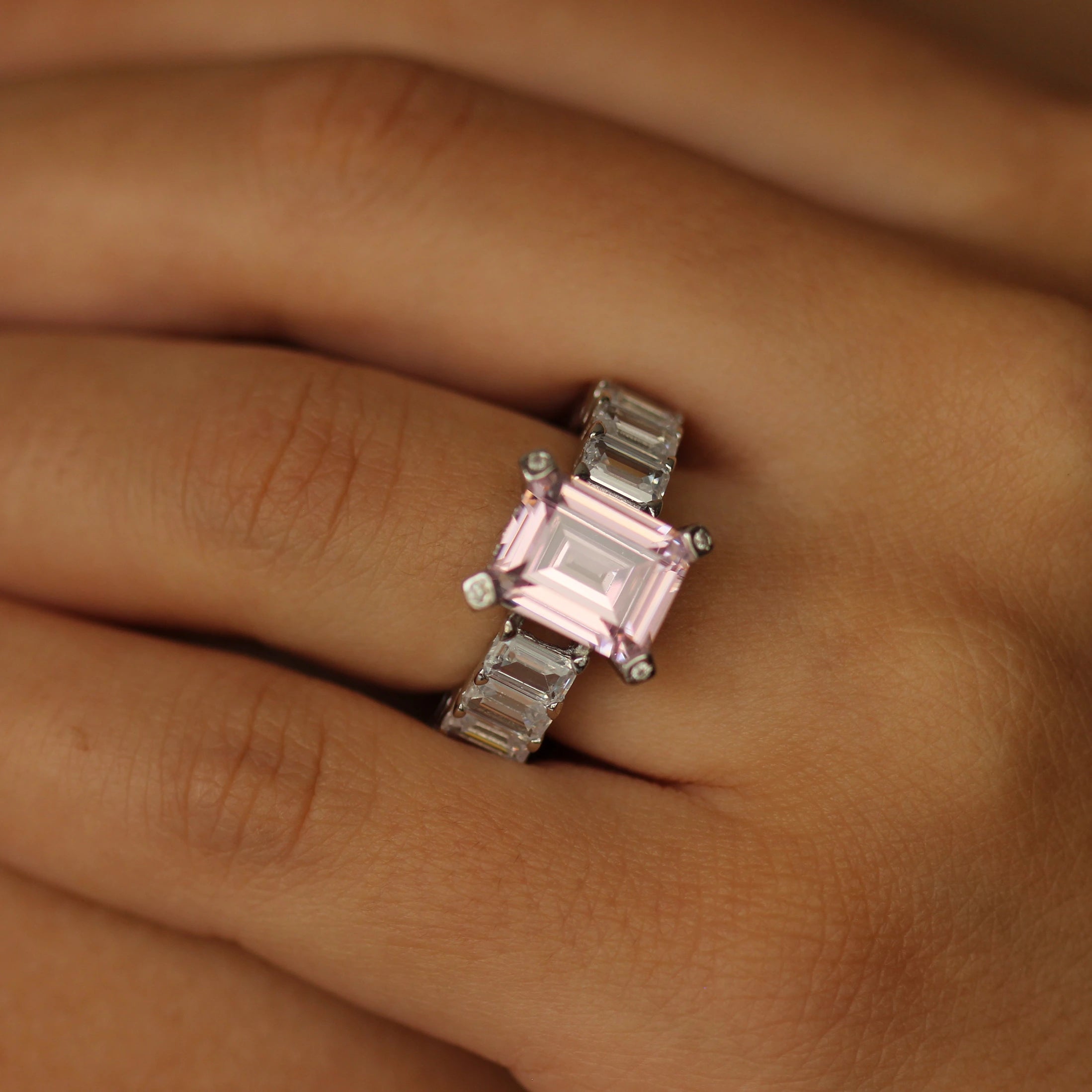 pink emerald ring with baguette side stones on hand