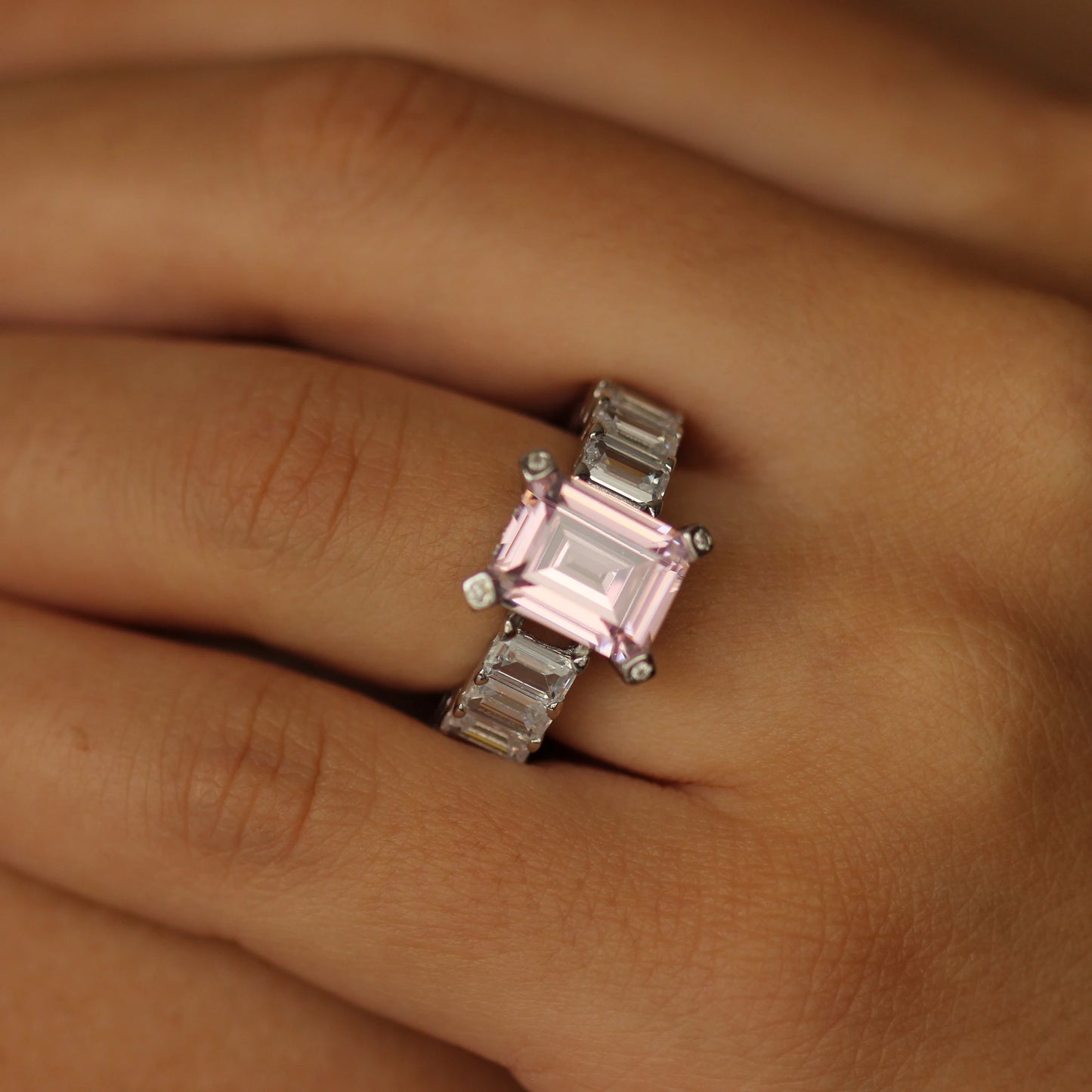 pink emerald ring with baguette side stones on hand
