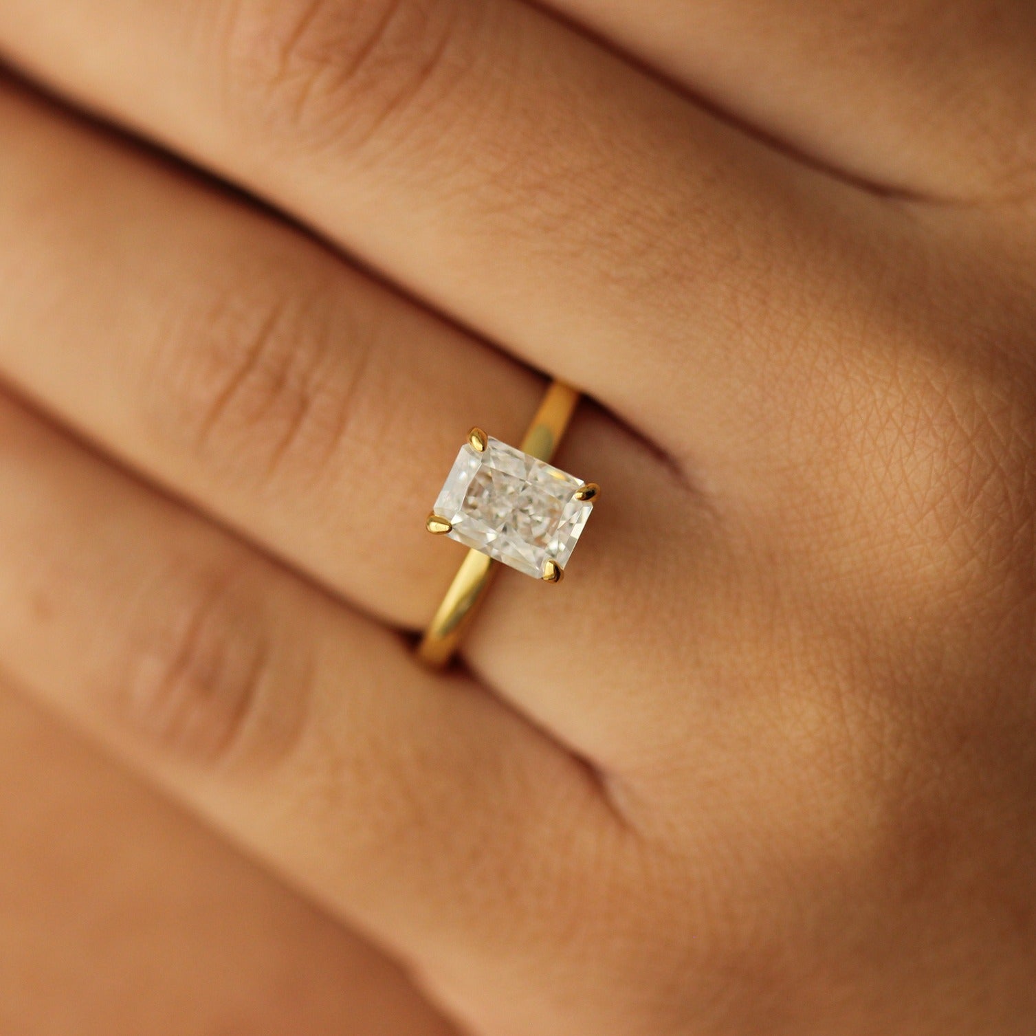 plain gold ring with 2 carat rectangle cubic zirconia centre stone on hand