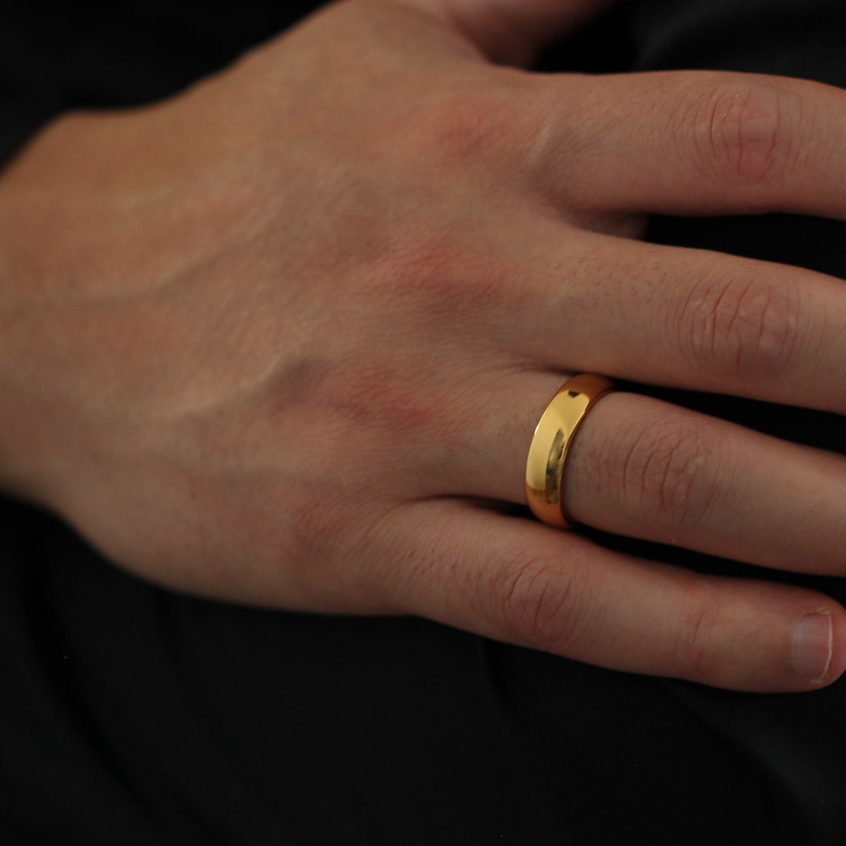 Male model with hands crossed wearing Men’s Polished Gold Wedding Band 6m