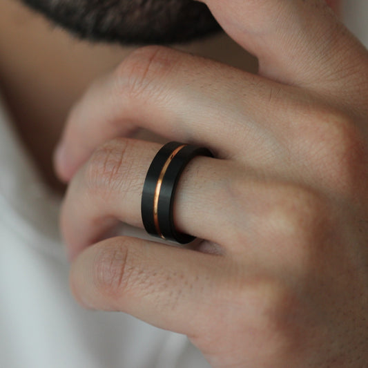 Male model wearing Odin rose gold and black men’s tungsten ring