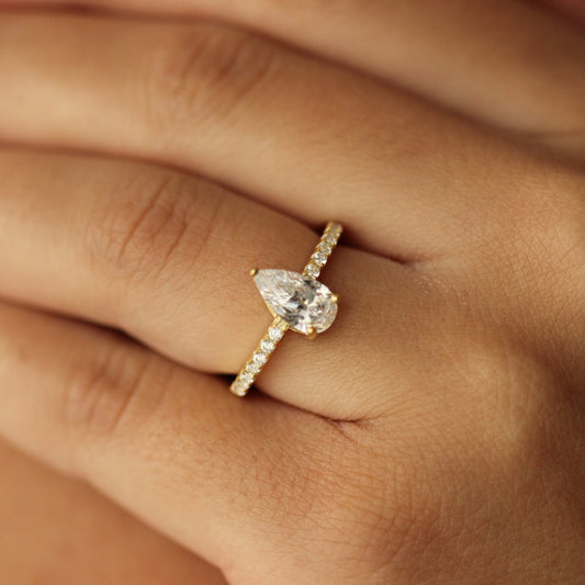 oslo pear ring with slim centre stone on half pave band on hand