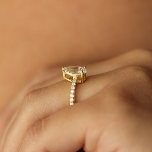 oslo pear ring with slim centre stone on half pave band on hand side profile