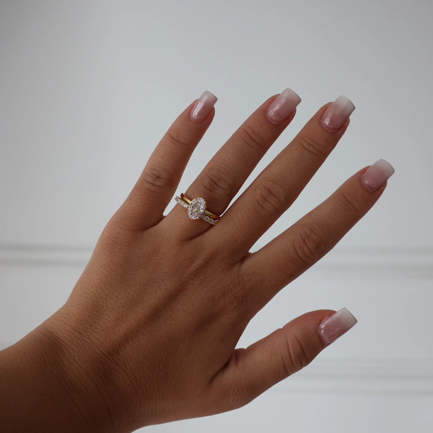 Oval 1.5ct hidden halo ring in gold with stacked eternity ring