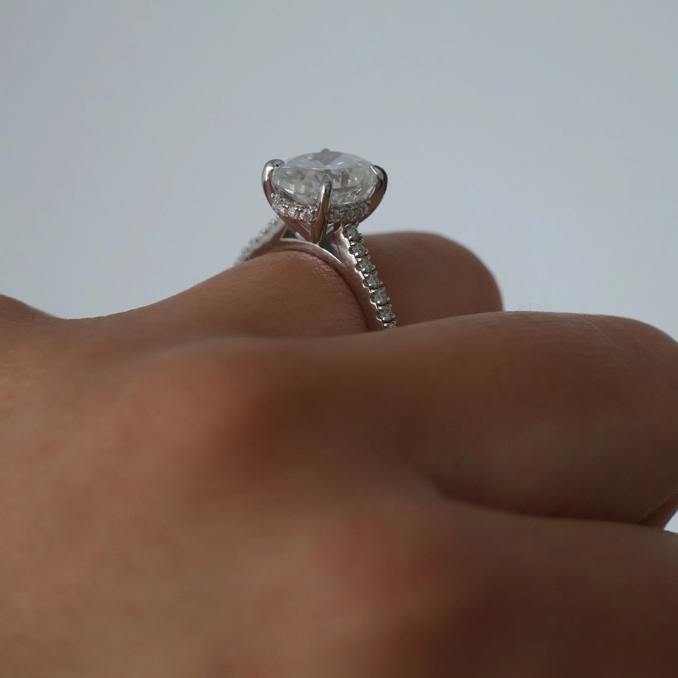 3 ct oval moissanite ring in silver with pave band and hidden halo