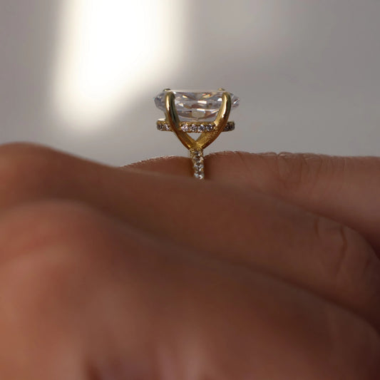 side profile of 3.5 carat crushed ice oval ring in 14k gold with hidden halo and pavé band