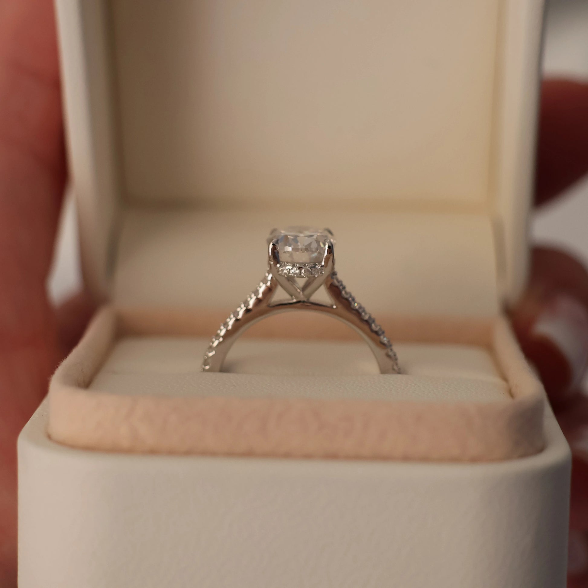 Oval moissanite engagement ring with hidden halo and pave band