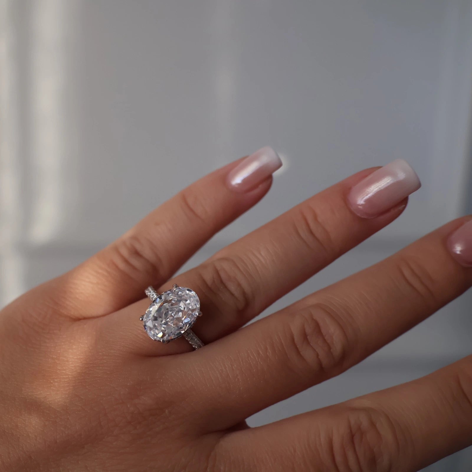 oval cut 4 ct silver ring featuring pavé band