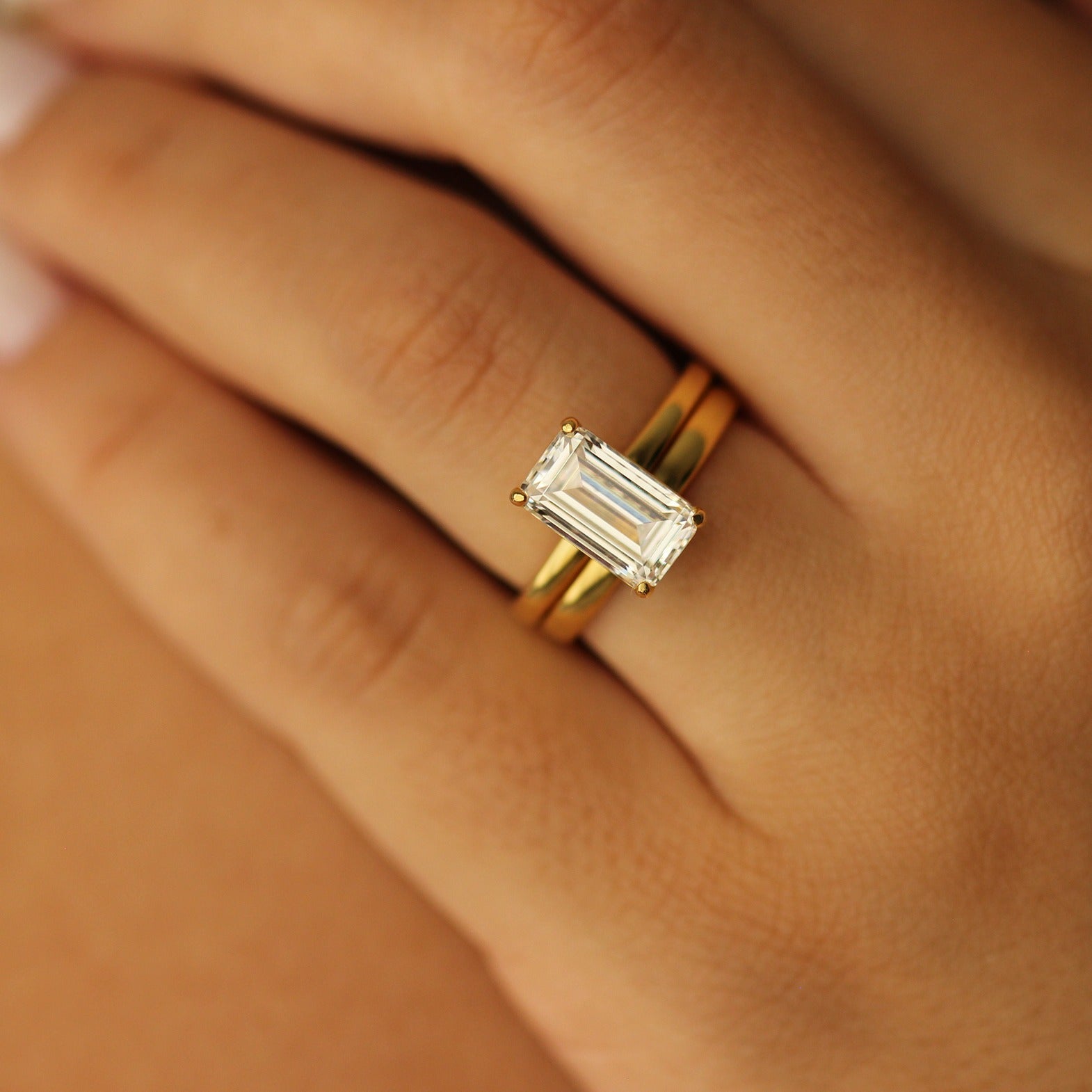 18k plain gold wedding band with emerald cut ring on hand