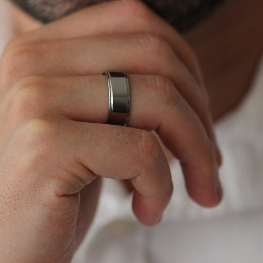 shiny silver mens ring with stepped edges model chin pose