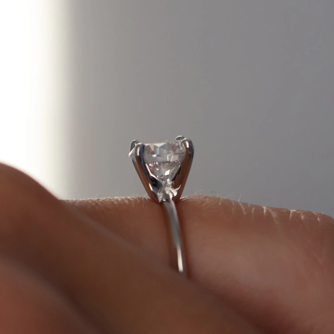 side profile of 1.3 carat round solitaire ring with thin band in silver