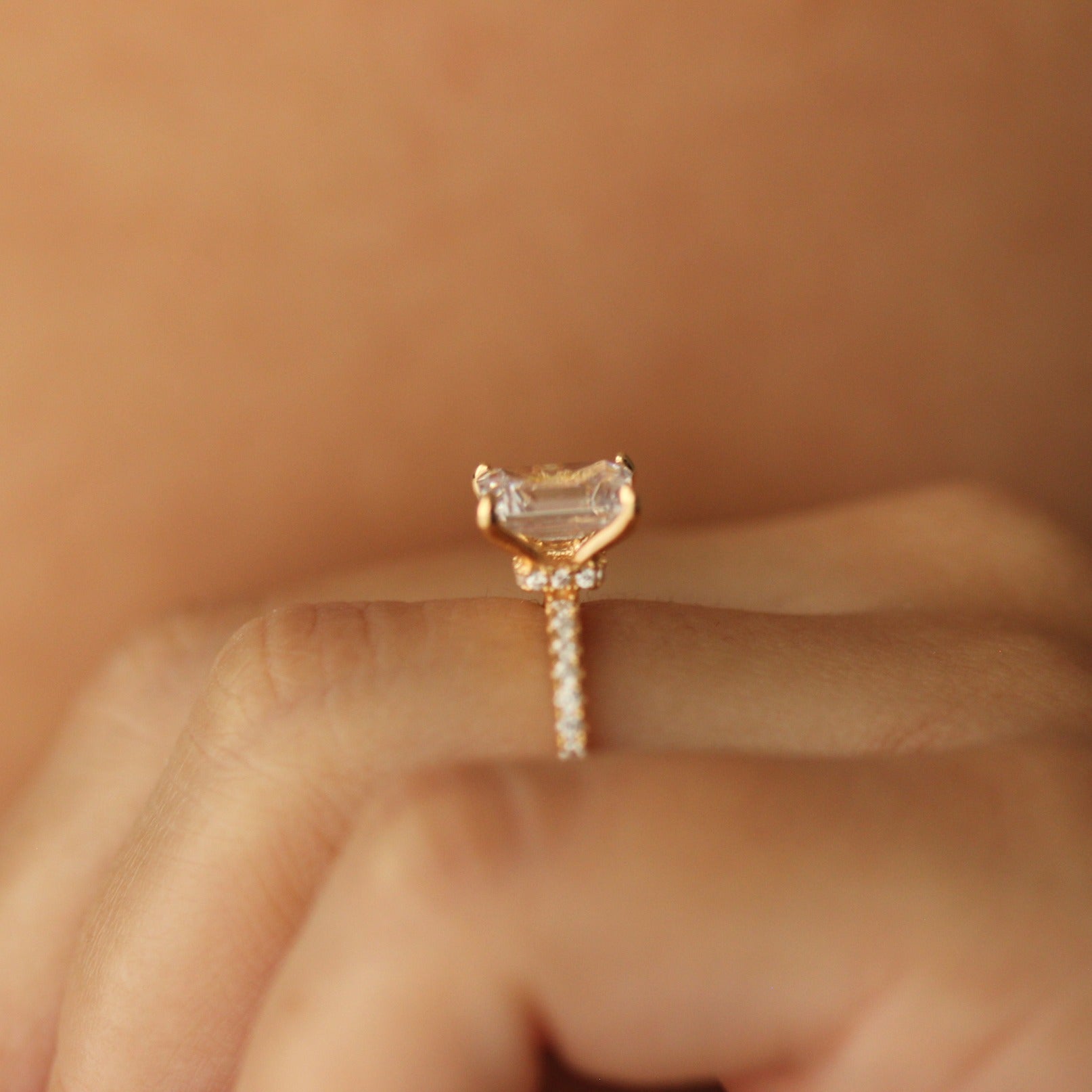 emerald cut gold ring with 2 carat cz stone  on hand side halo