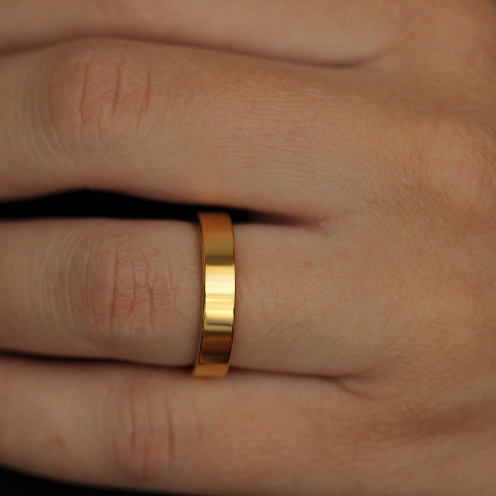 shiny gold flat wedding band close up