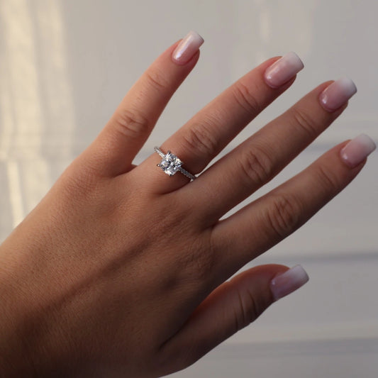Silver ring featuring a 2 carat cushion cut cubic zirconia and pavé set band
