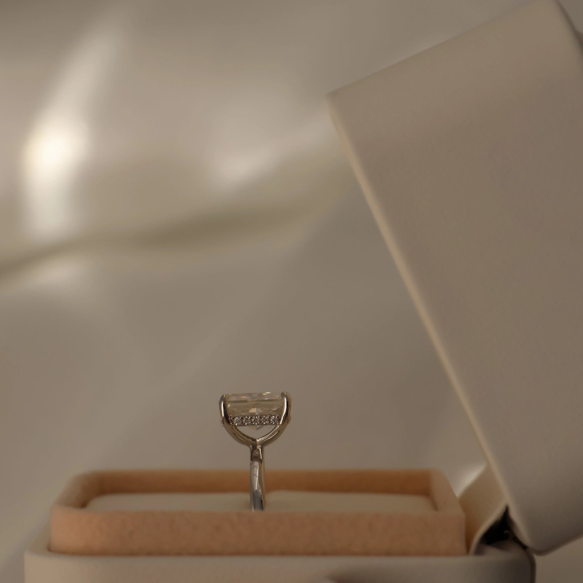 Silver 3ct radiant cut moissanite engagement ring displayed inside a proposal box