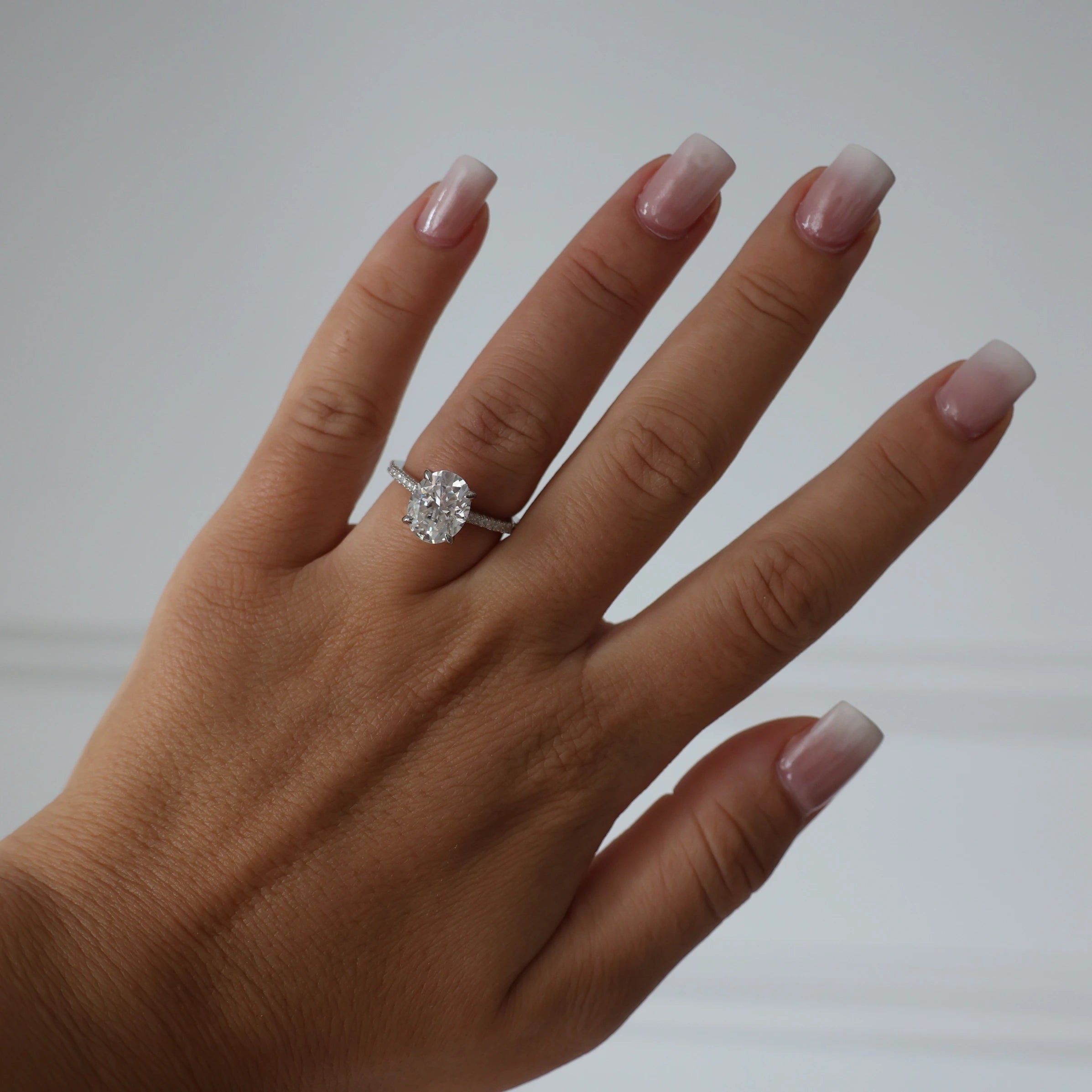 silver oval cut 3 ct moissanite ring featuring hidden halo
