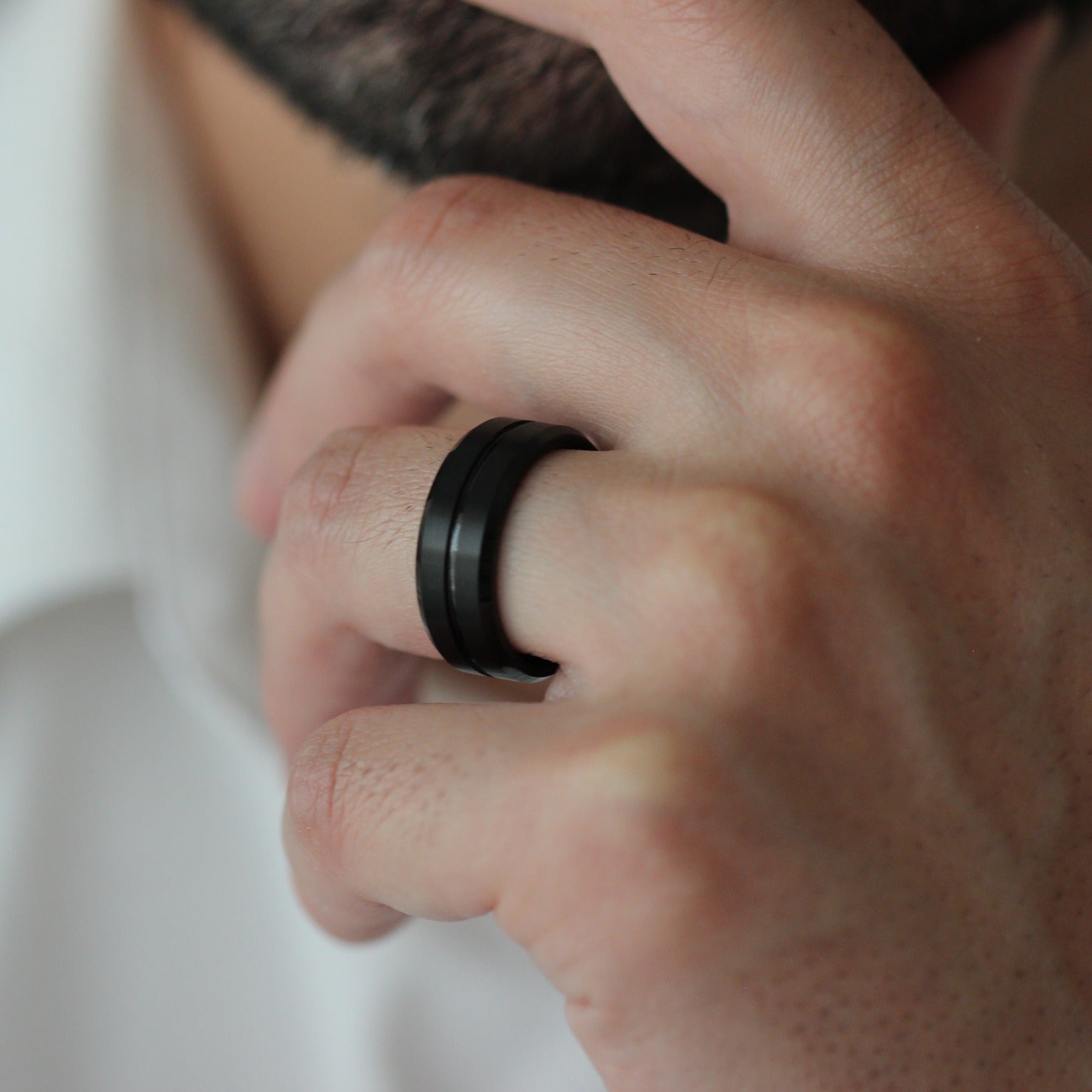 Male model touching chin wearing Thor black men’s tungsten ring